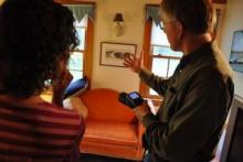 Energy Auditor showing a customer a potential problem area of their home, using thermal imaging.