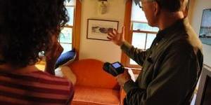 Energy Auditor showing a customer a potential problem area of their home, using thermal imaging.